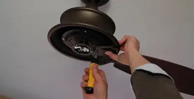 Electrician installing ceiling fan mounting bracket and fixture in Columbia, SC