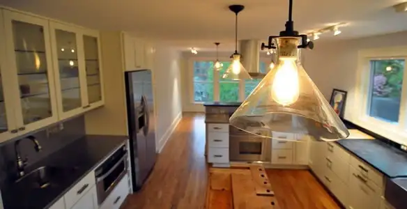 Residential electrician installing modern indoor light fixture in a home in Columbia, SC