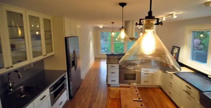 Residential electrician installing modern indoor light fixture in a home in Columbia, SC